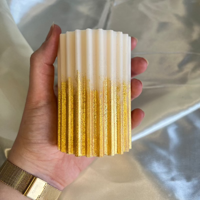 Duurzame handgemaakte kaars uit Nederland, verrijkt met een subtiele gouden glitterafwerking.
